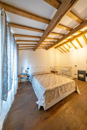 a bedroom with a bed in a room with wooden ceilings at Loft Elegante nel centro di Dozza, città d'Arte in Dozza