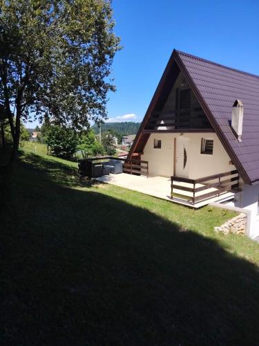 a house with a large yard next to a building at Vikendica Luka in Han Pijesak