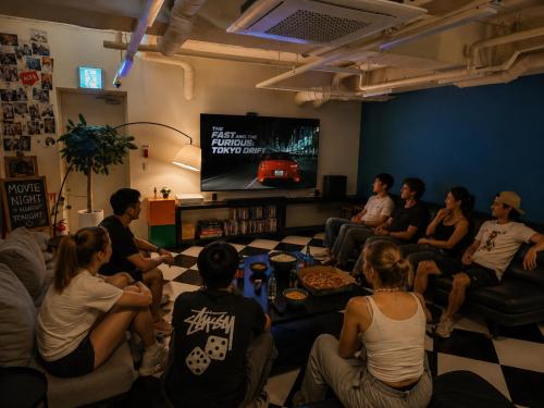 a group of people sitting in a room watching tv at Bluedot Poshtel in Seoul