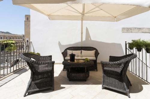 two chairs and a table with an umbrella on a patio at Biccari 6 Terrace Apartament in Lecce