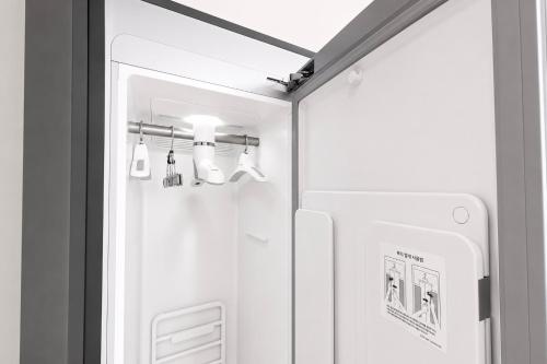 a small refrigerator in a kitchen with a light at Osan J Hotel in Osan