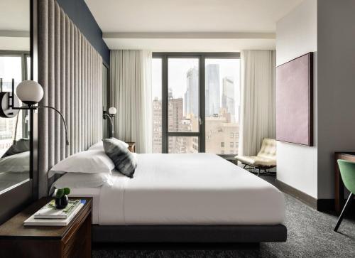 a bedroom with a large bed and a large window at Kimpton Hotel Eventi by IHG in New York