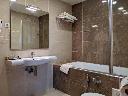 ein Badezimmer mit Badewanne, Waschbecken und Dusche in der Unterkunft Hotel Zenith in Oran