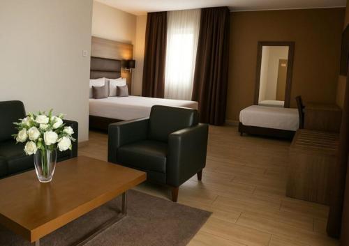 ein Hotelzimmer mit Bett und Wohnzimmer in der Unterkunft Hotel Zenith in Oran