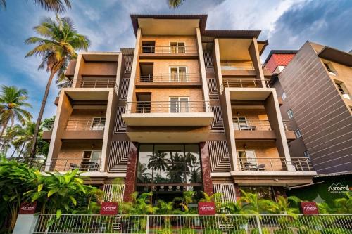 a building with palm trees in front of it at Summit Calangute Resort & Spa in Calangute