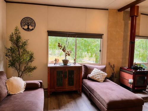 a living room with a couch and a window at Willow Cabin at The Reset Retreat in Charbon