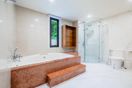 a large bathroom with a tub and a shower at Westkey Patong Hotel in Patong Beach