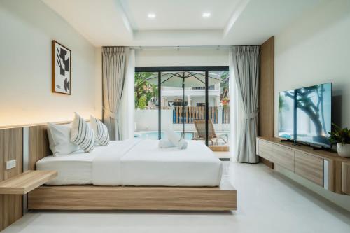 a bedroom with a large bed and a television at Westkey Patong Hotel in Patong Beach