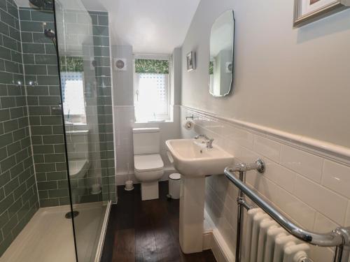a bathroom with a sink and a toilet and a shower at Cosy Cottage in Buxton