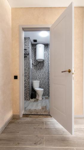 a bathroom with a toilet and a white door at Kobuleti Lounge in Kobuleti
