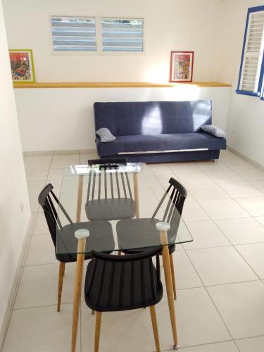 a table and chairs in a living room with a couch at Appartement cosy Le Marin 60 m² + jardin in Le Marin