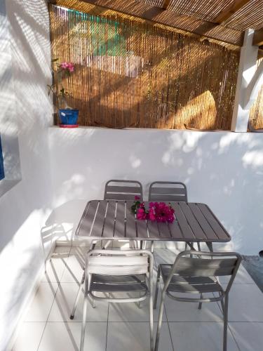 a table and chairs with flowers on a patio at Appartement cosy Le Marin 60 m² + jardin in Le Marin