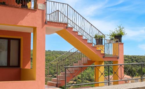a staircase leading up to a building with a balcony at Charming apartment in Nughedu Santa Vittoria - 90 m² with fireplace in Nughedu Santa Vittoria