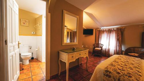 a bedroom with a bed and a bathroom with a toilet at La Casona de Lucía in Sigüenza