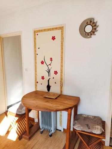 a room with a wooden table with a vase on the wall at Studio confortable, Rennes les bains, 17 m² + Balcon in Rennes-les-Bains