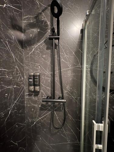 a bathroom with a shower with a black marble wall at Chill & Play in Casteljaloux