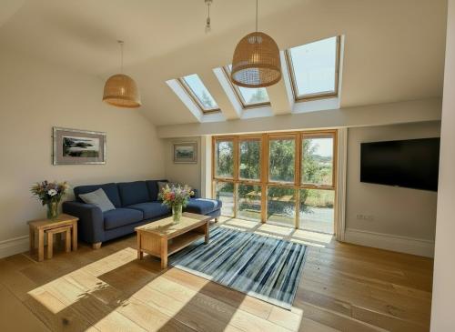 a living room with a blue couch and a tv at Cymyran Terrace in Holyhead