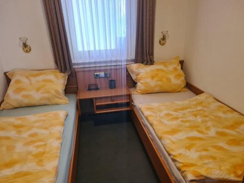 a small room with two beds and a window at Haus Goldregen - App. 223 in Thalfang