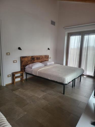 a bedroom with a bed and a large window at Le Ghie in Mondovì