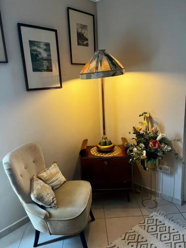 a living room with a chair and a table with a lamp at Budapest Airport Smiley House in Gyál