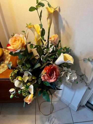 a bouquet of flowers in a vase on a table at Budapest Airport Smiley House in Gyál