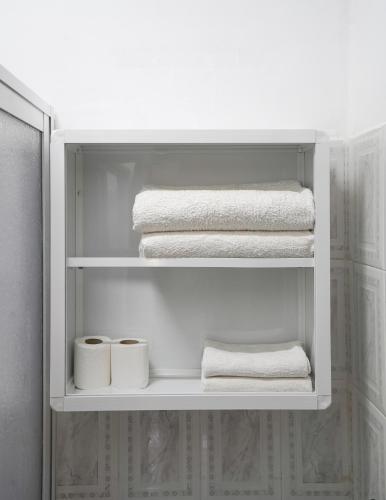 a white cabinet with towels and folded towels at Riad Salt River in Martil