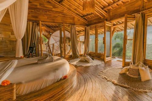 a bedroom with a large bed in a wooden room at Bamboo Villa with Amazing mount agung view in Selat