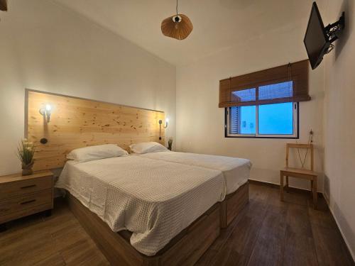 a bedroom with a large bed and a window at Casa Saudade Beach House in Zambujeira do Mar