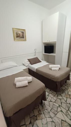 two beds in a room with towels on them at Hotel Cilene in Viareggio