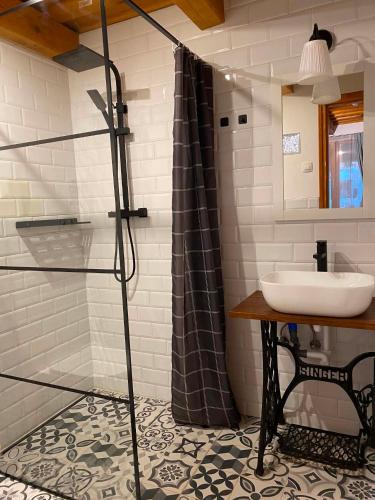 a bathroom with a sink and a shower at Flóra Apartmanok in Kehidakustány
