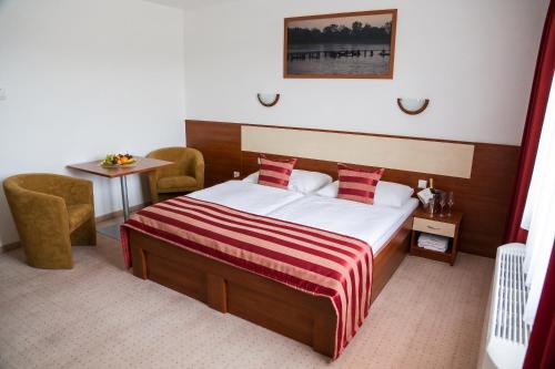 a hotel room with a bed and a table at Hotel Auto Jas in Nitra