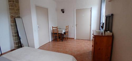 a bedroom with a bed and a table and a dining room at E I PERLES de AIME in Laurac-en-Vivarais