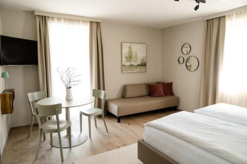 a bedroom with a bed and a table and a couch at Gasthof Thünauer in Offenhausen