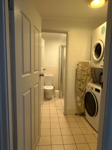 a bathroom with a toilet and a washing machine at Coconuts - 3 bedroom 3 bathroom townhouse with tennis court in Nelson Bay