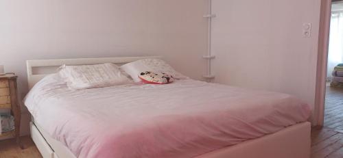 a white bed with a stuffed animal sitting on it at La Parenthèse d'Ouilly in Pont-d'Ouilly