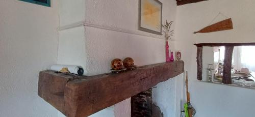 a fireplace with a wooden mantle in a room at La Parenthèse d'Ouilly in Pont-d'Ouilly