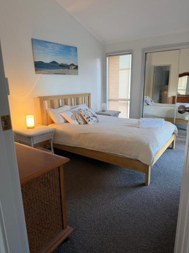 a bedroom with a large bed and a desk at Coconuts - 3 bedroom 3 bathroom townhouse with tennis court in Nelson Bay