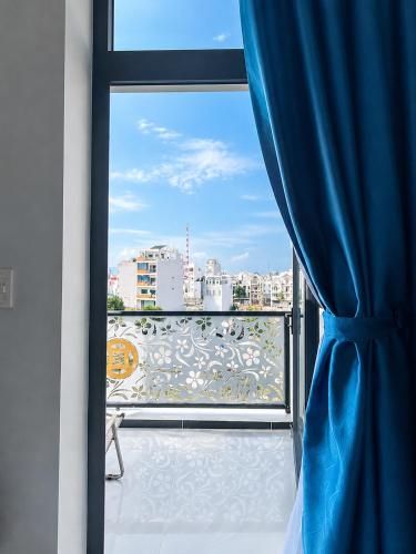 a view of a balcony with a blue curtain at Sand Sea Hotel Phan Thiết in Phan Thiet