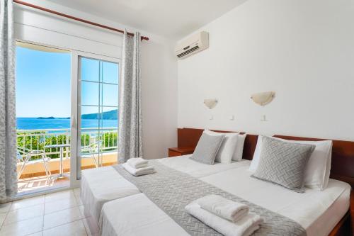a bedroom with a bed with a view of the ocean at Hotel Smaragdi in Chrysi Ammoudia