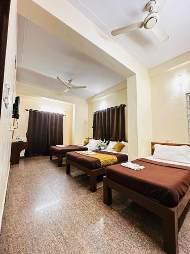 a room with three beds and a ceiling at Sahara Residency Mysore in Mysore