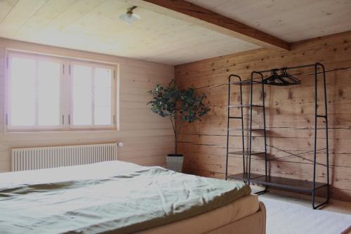 a bedroom with a bed and a wooden wall at BergZeit- Relax Explore Belong in Stalden
