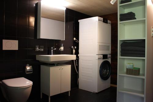 a bathroom with a white sink and a toilet at BergZeit- Relax Explore Belong in Stalden