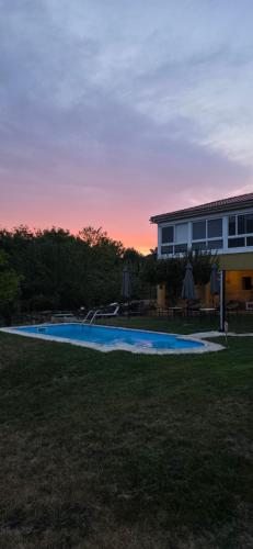 a swimming pool in a yard next to a house at Palleira da Meiroá in Esgos