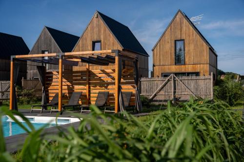 a wooden house with a pool in front of it at Letnisko Rusinowo in Jarosławiec