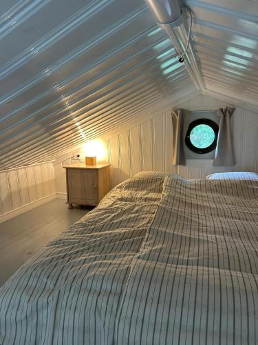 a large bed in a room with a window at 'Ekhaga Cabins' Lillestugan in Viddviken