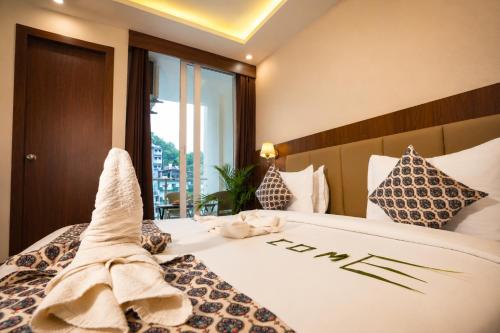 a hotel room with a bed with towels on it at Sunburry Hotel Tapovan Rishikesh in Narendranagar