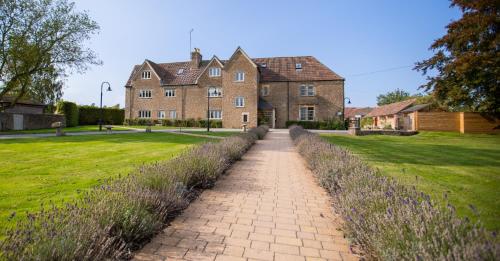 a brick pathway leading to a large house at The Lighthouse Bed & Breakfast in Frome