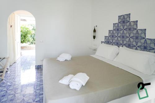 a bedroom with a large bed with towels on it at Hotiday Vulcano Porto in Vulcano