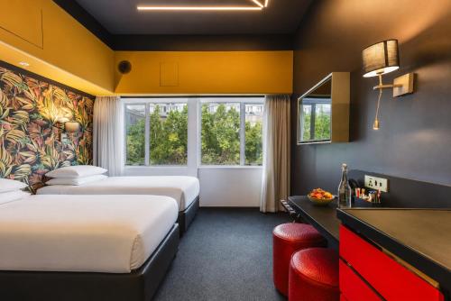 a hotel room with two beds and a desk at ONOMO Hotel Foreshore in Cape Town