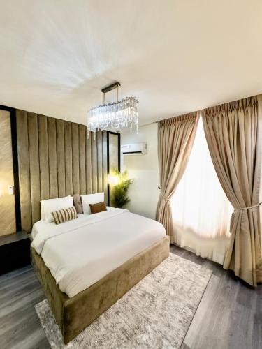 a bedroom with a large bed and a large window at Luxury 2BR Oasis in Lekki
